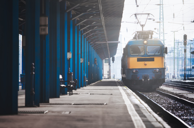 Vonat egy magyar vasútállpomáson, kék oszlopok között a Keleti pályaudvarnál