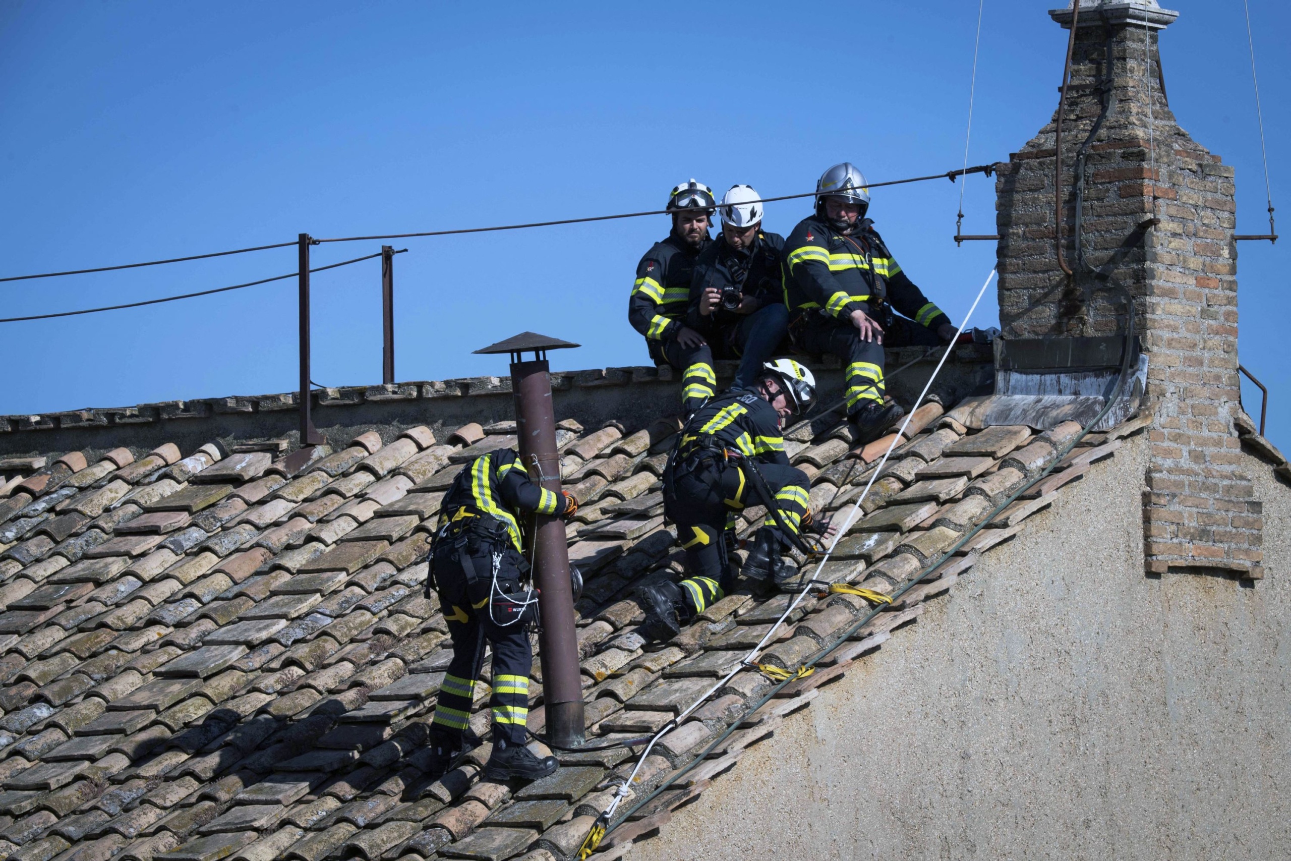 A tűzoltók javítják a kéményt a Sixtus-kápolna tetején.