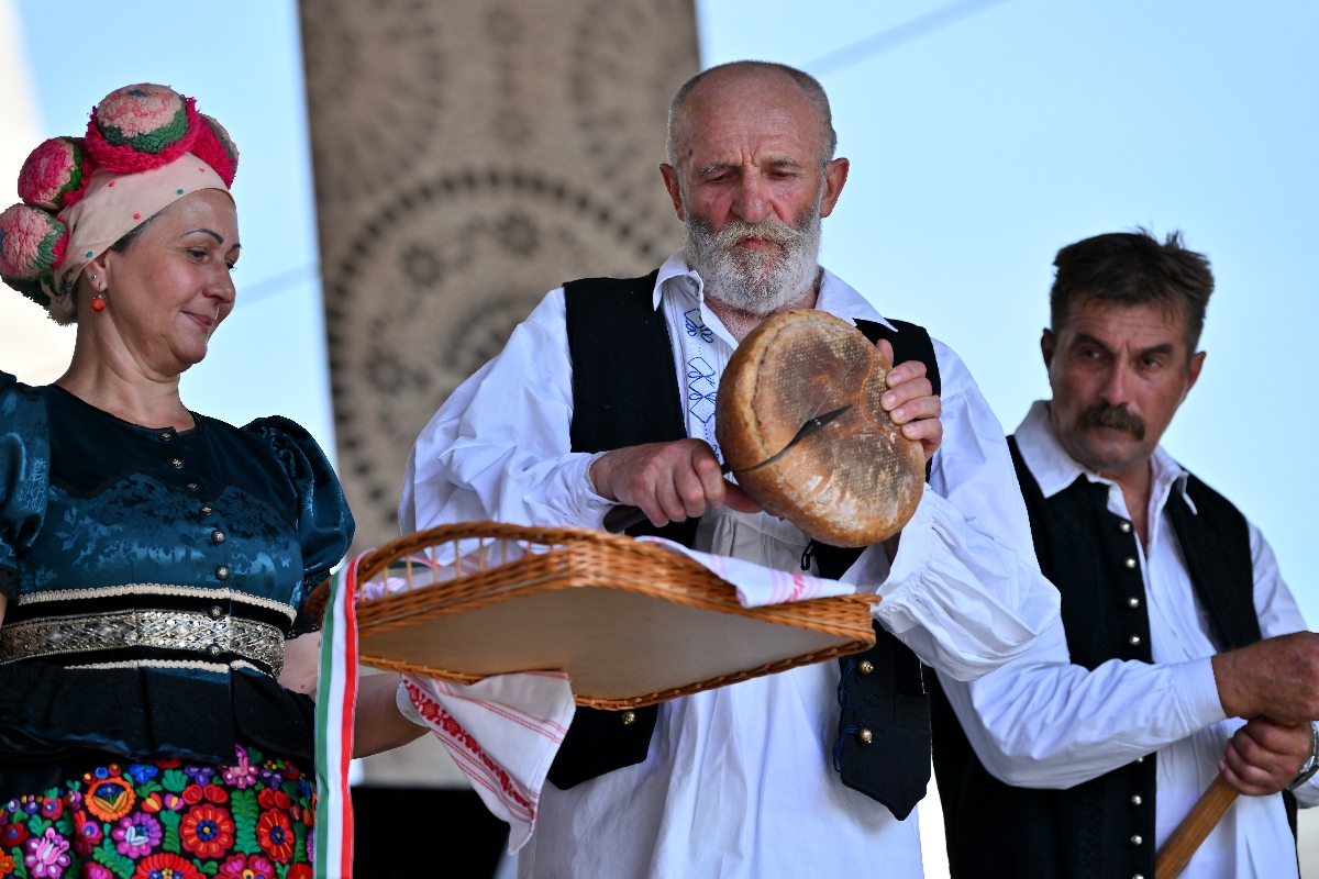 Nagy Béla népi iparmûvész, fafaragó (k) megszegi a megszentelt új kenyeret