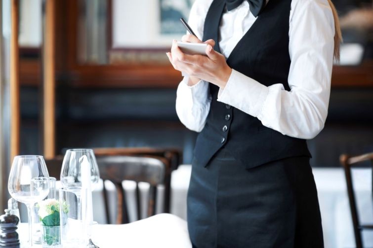 Pincér egy asztalnál egy étteremben.