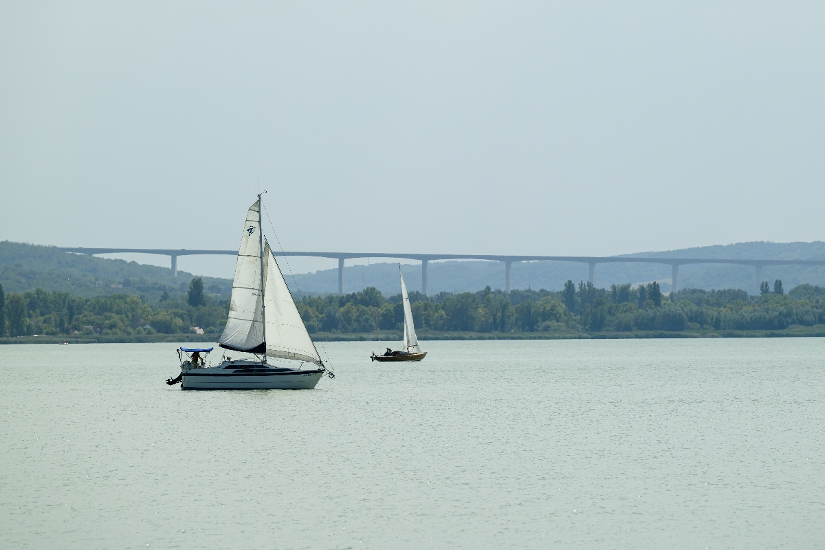 Vitorlás a Balatonon Tihany közelében, háttérben a Kőröshegyi völgyhíd
