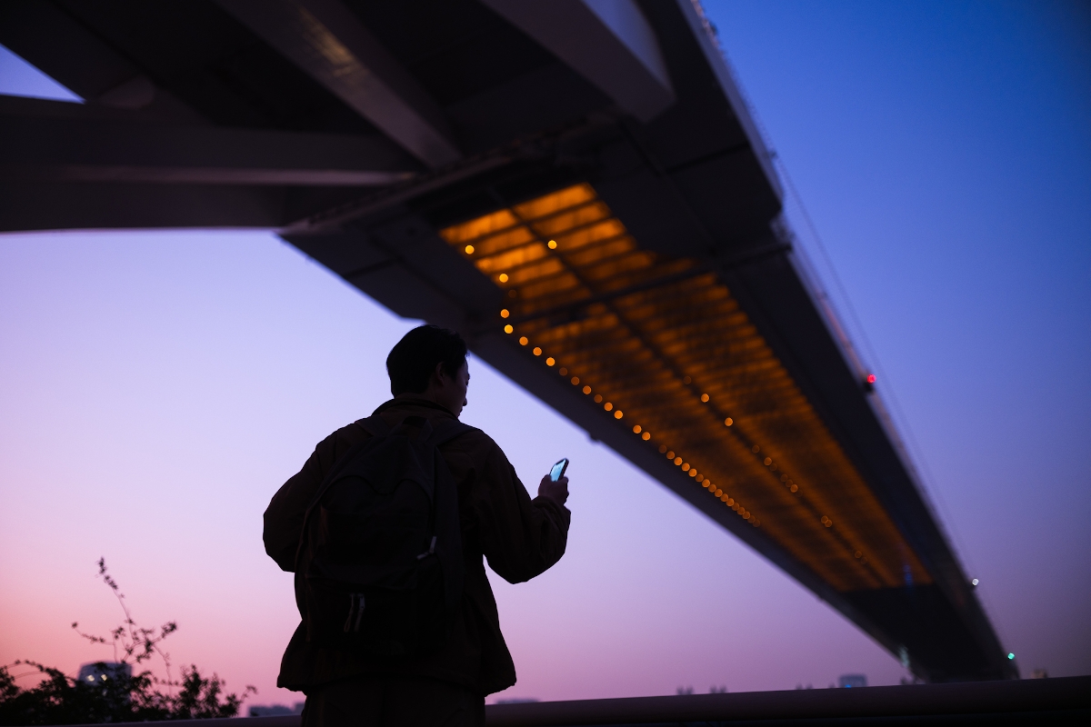 Egy ember egy híd árnyékában