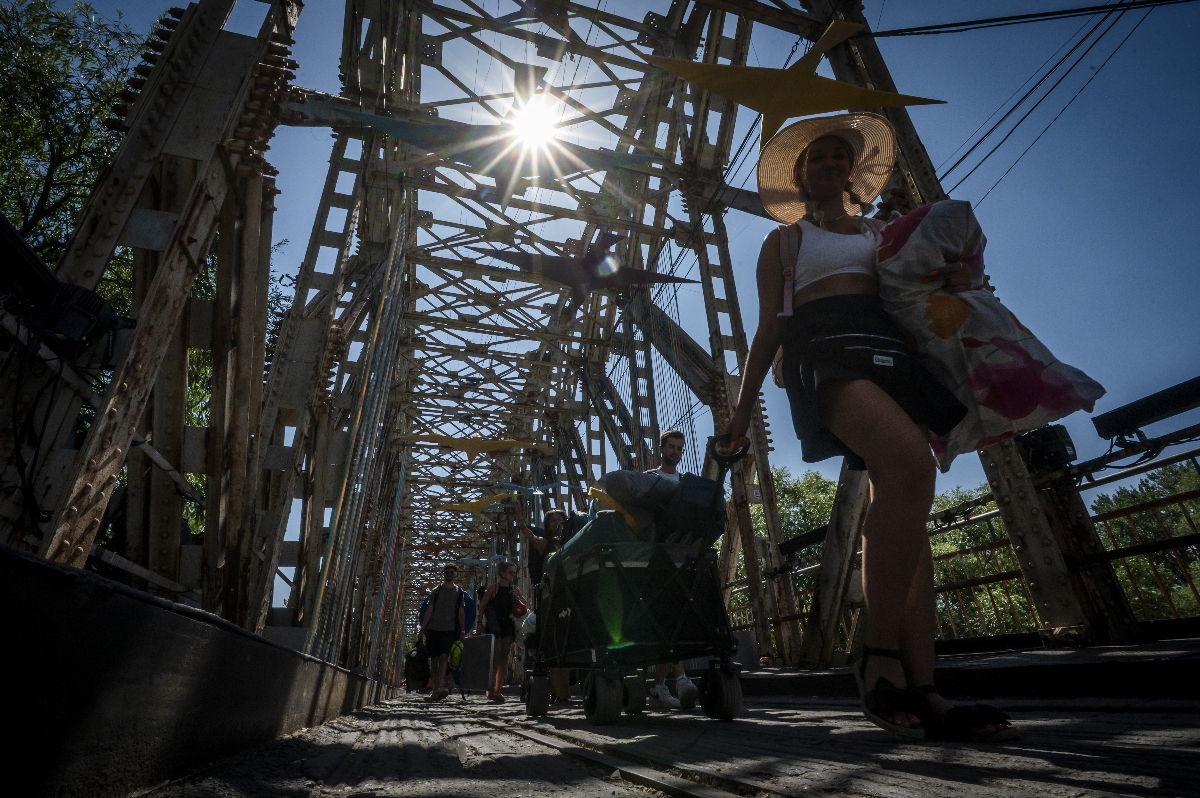 Fiatalok távoznak a K-hídon az óbudai Hajógyári-szigetrõl