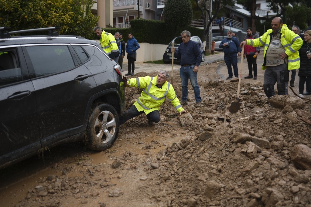 Autót próbálnak kiszabadítani a sárból