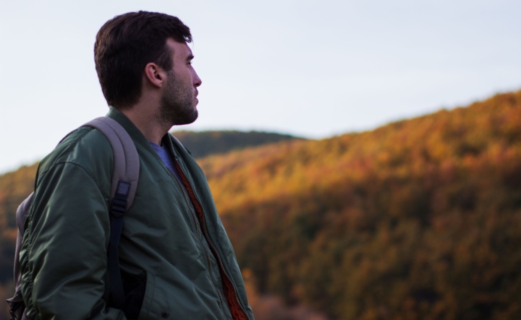 Egy férfi nézi a tájat az erdőben.