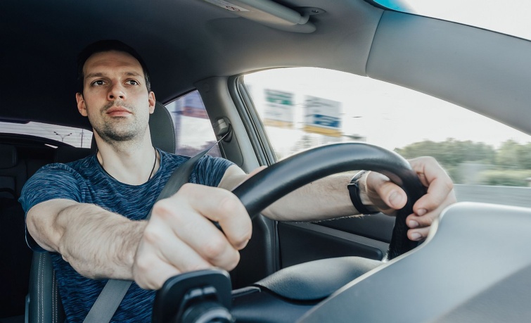 Egy férfi autót vezet.