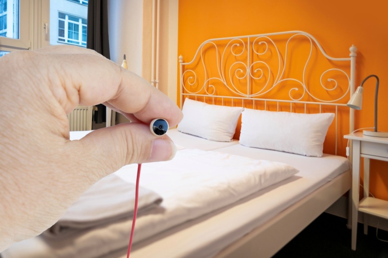 hotel-rejtett-kamera - Startlap Utazás Apró, rejtett kamerát tart egy kéz egy hotelszobában