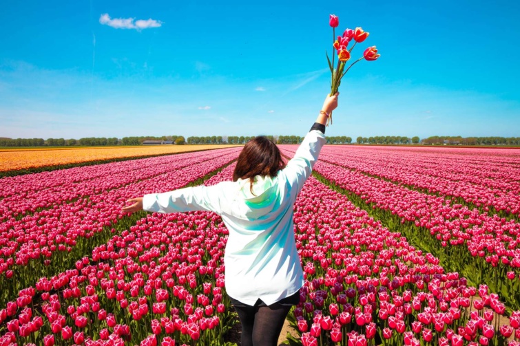 Vidám nő tulipáncsokorral