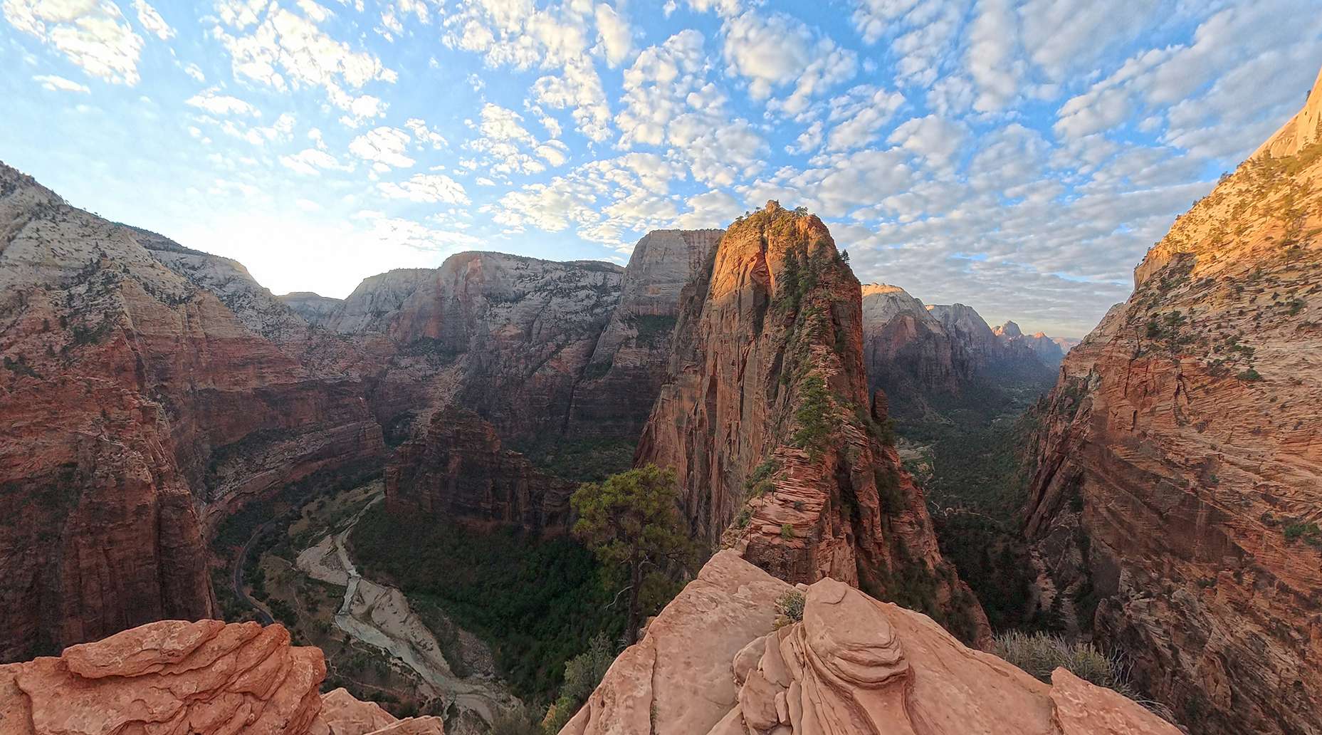 Vörös színű szikás hegyek és egy kanyon látképe.