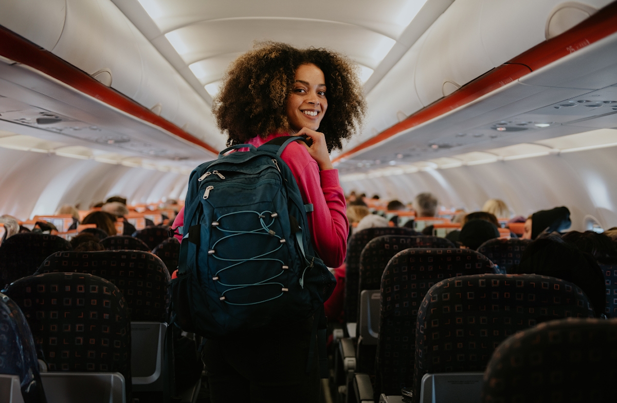 Fiatal nő egy repülőgép fedélzetének sorai között