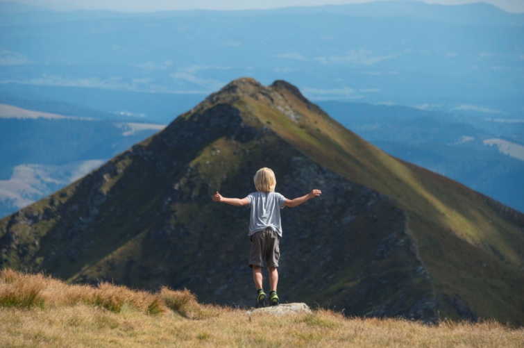 Kisgyerek sétál a hegyek között.