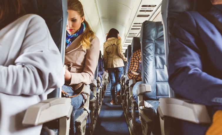 Interior of airplane with people sitting on seats - Startlap Utazás Utasok egy repülőgépen.