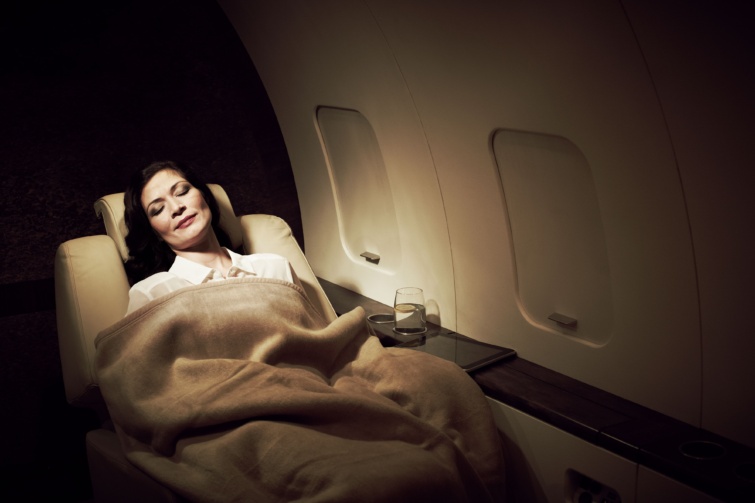 Betakarva alvó nő repülőgépen.