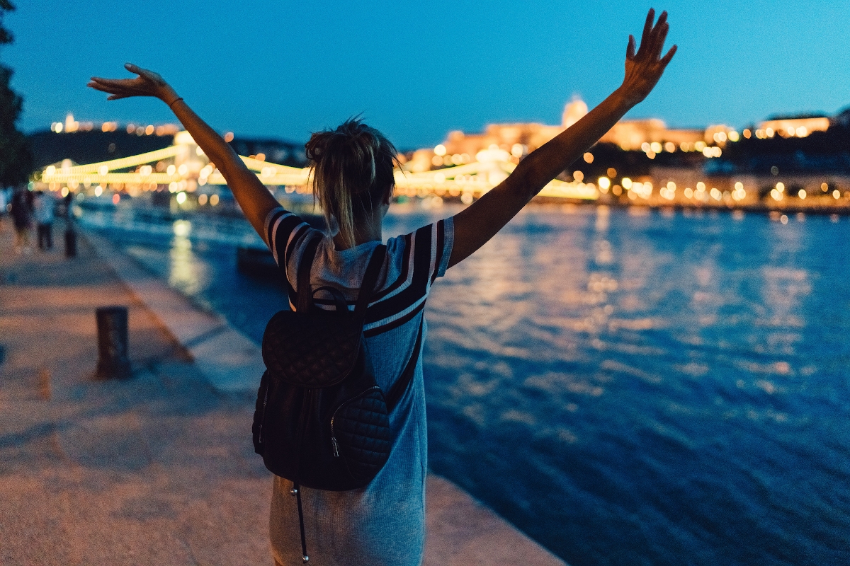 Fiatal nő integet a Duna partján Budapesten