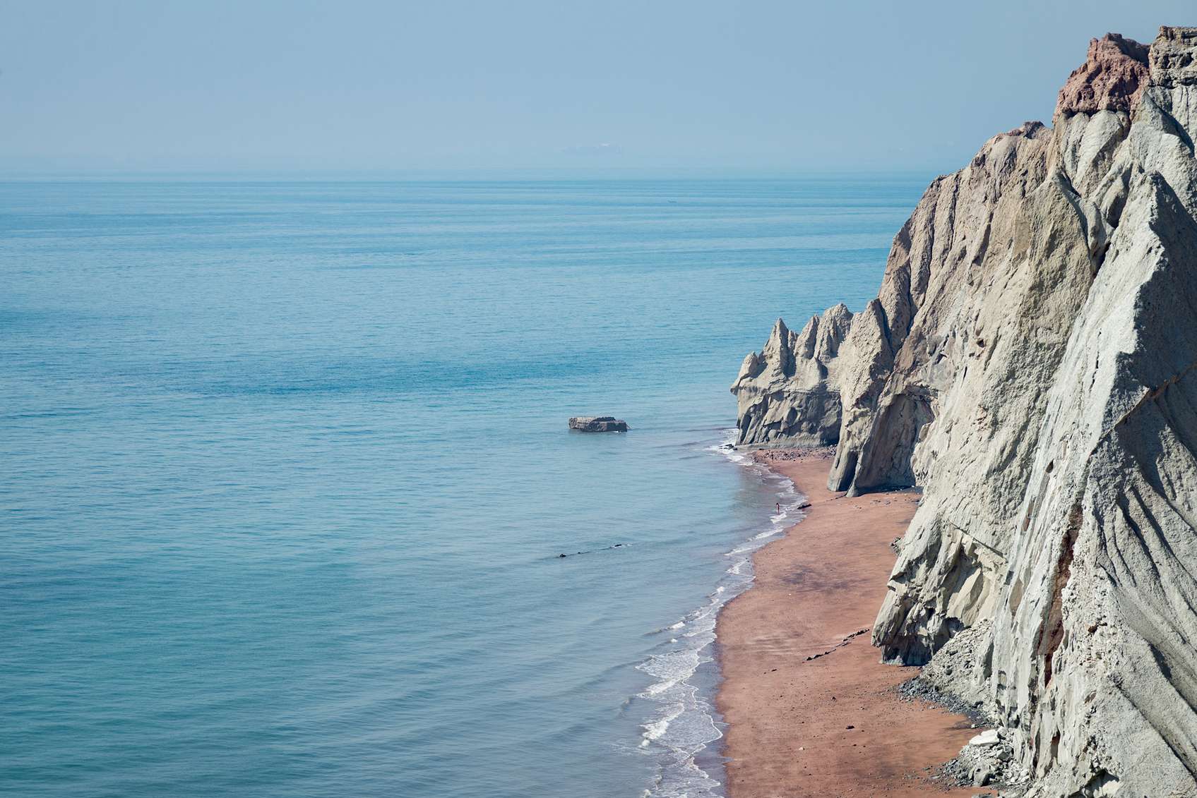 kék tenger mellett meredek sziklafal