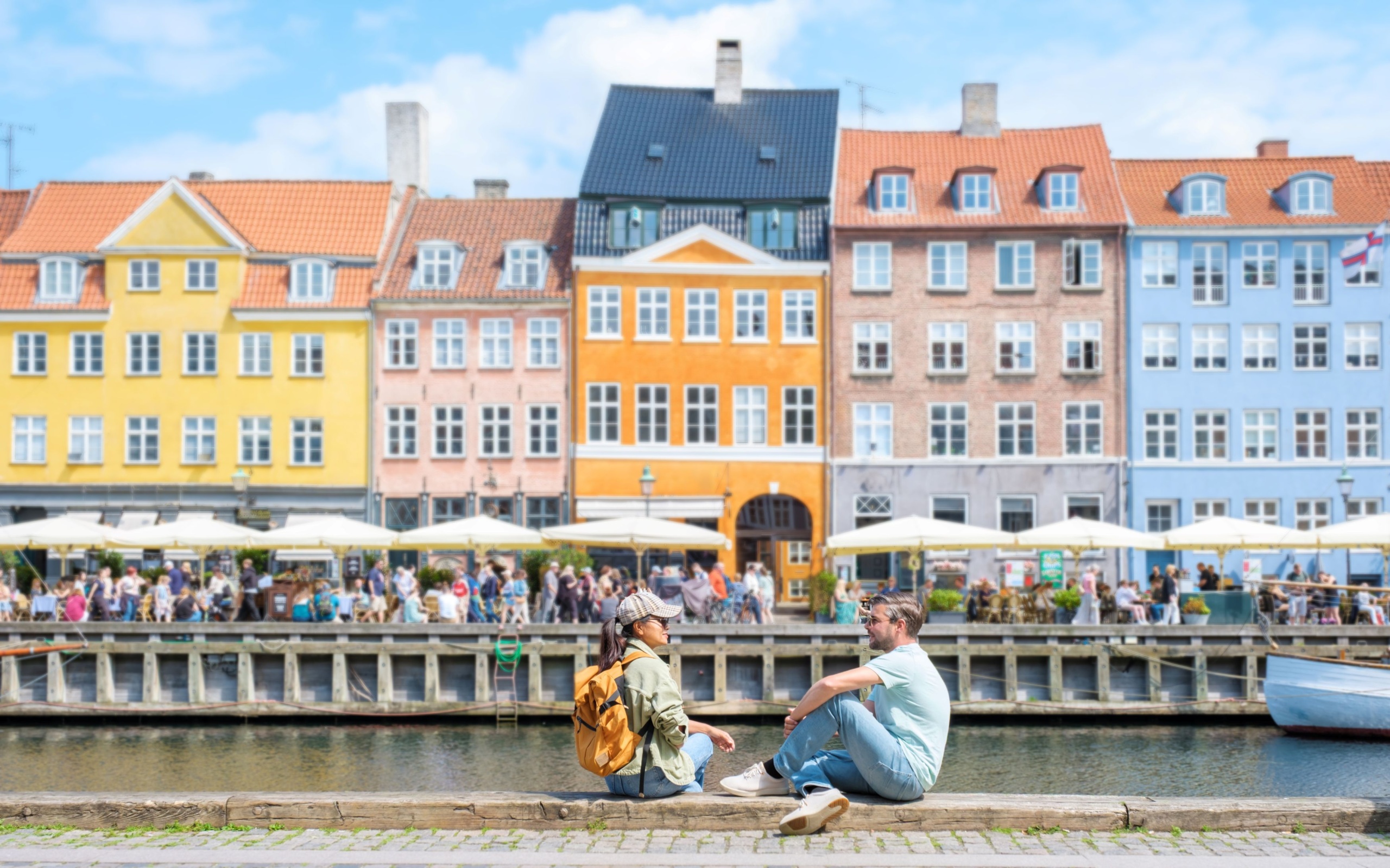 Csatorna mellett beszélgető emberek Koppenhágában.