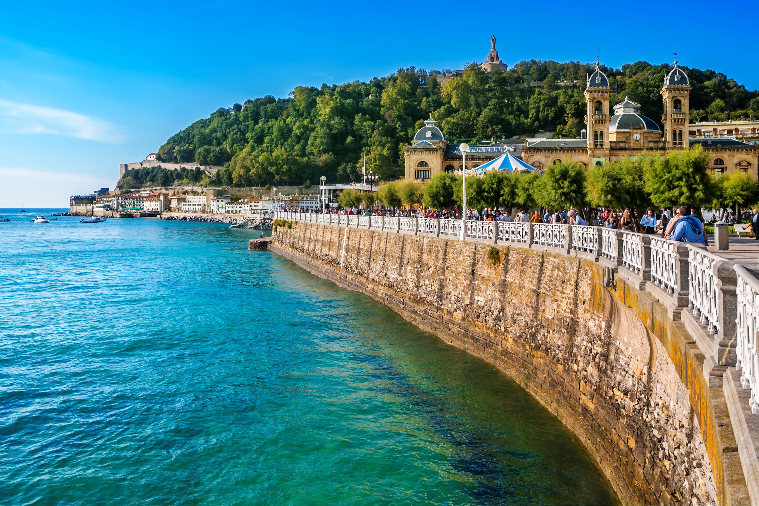 Kék tenger sziklafallal és fehér korláttal.