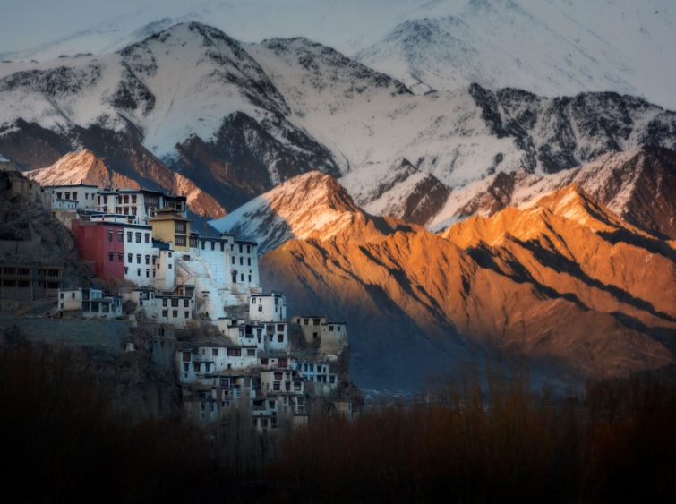 Hófödte hegycsúcsok fehér falú házakkal.