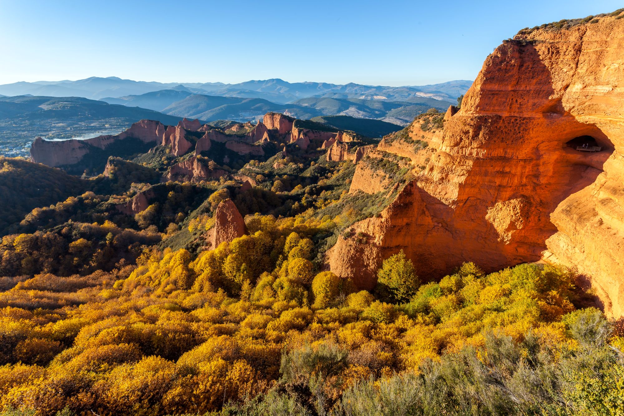 Vörös sziklafalak zöld erdők között.