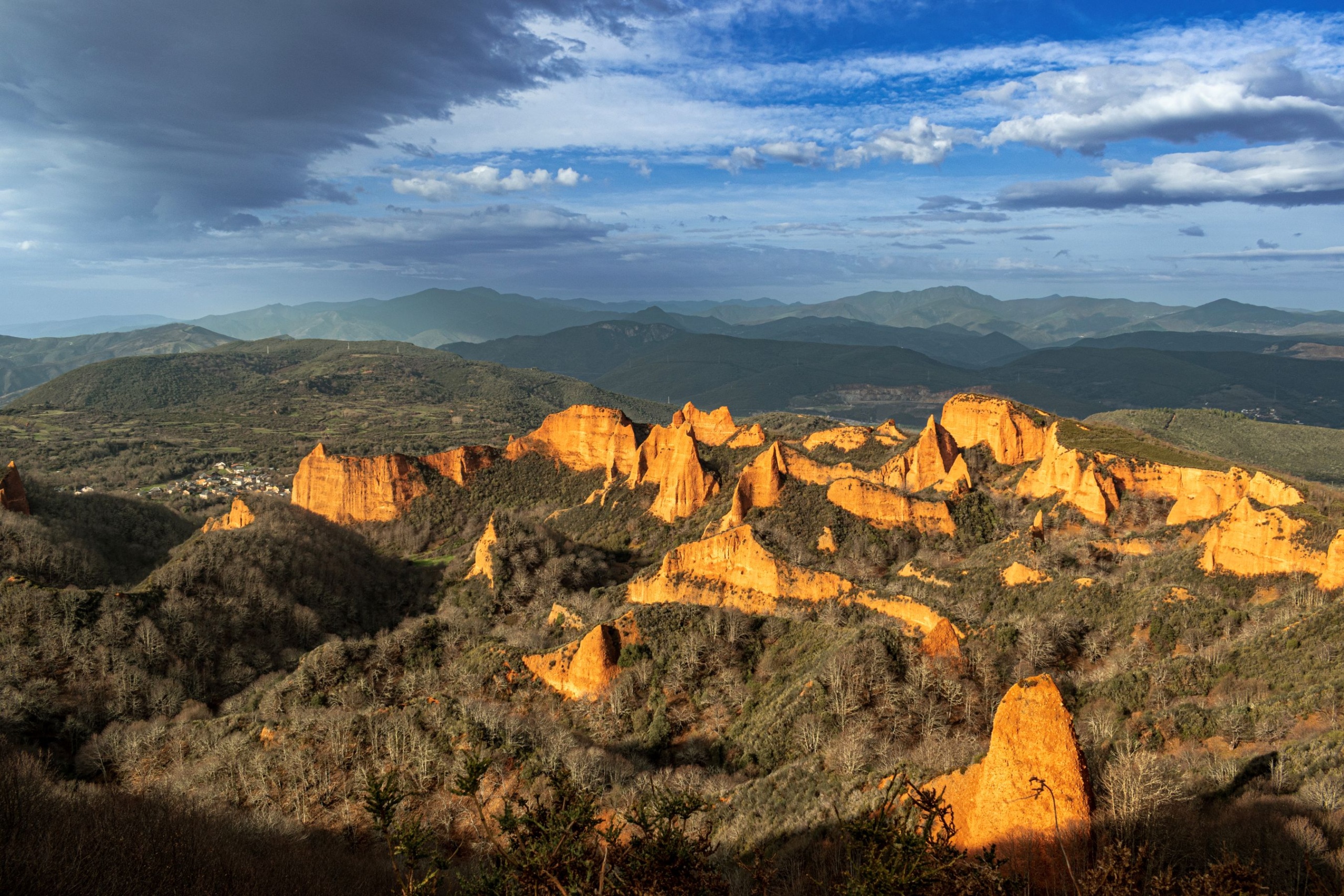 Vörös sziklafalak zöld erdők között.