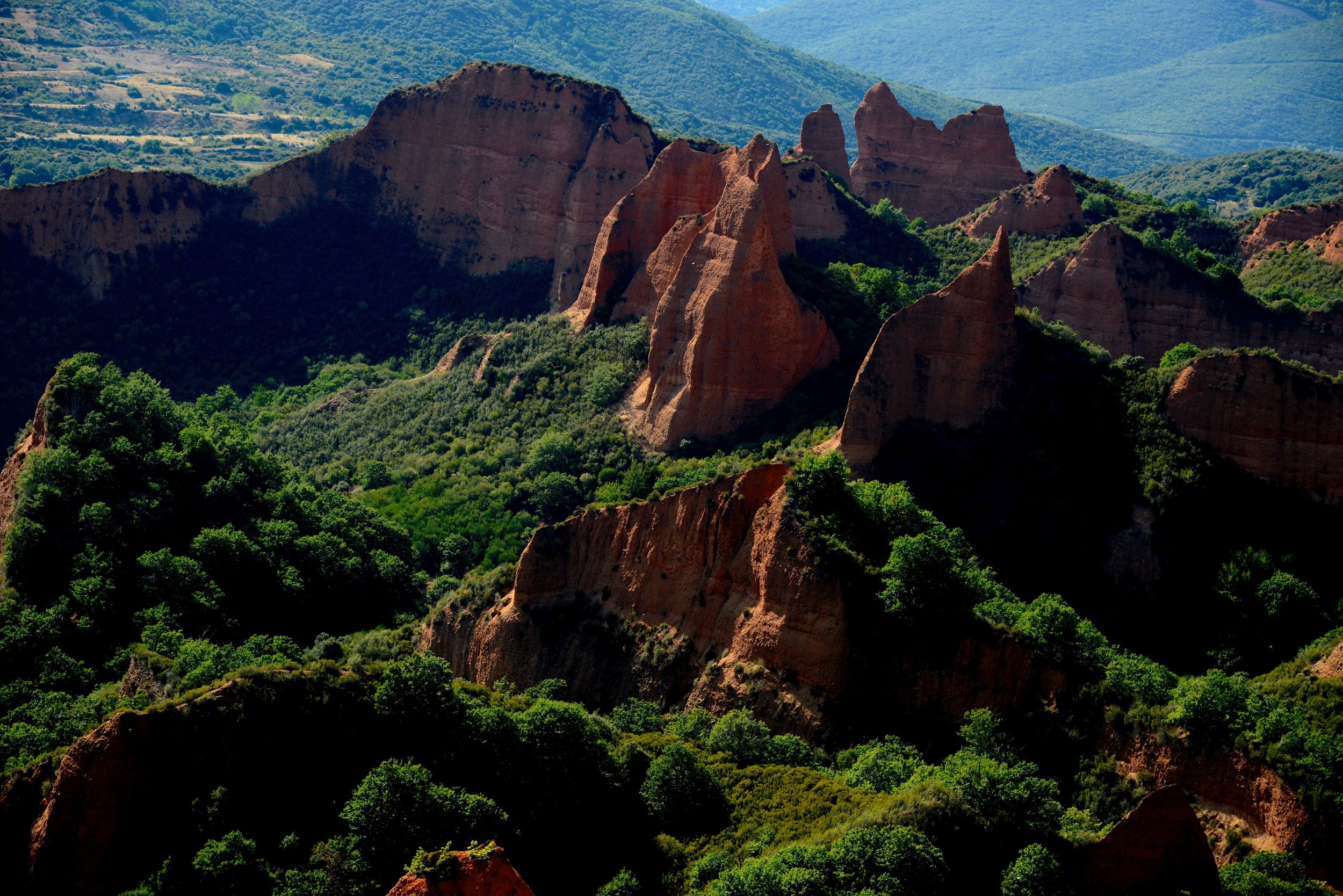 Vörös sziklafalak zöld erdők között.