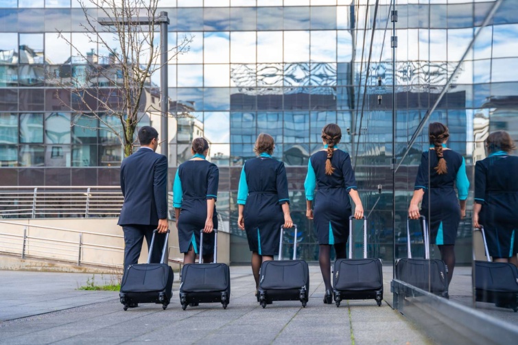 Légiutas-kísérők sétálnak bőrönddel egy épület előtt