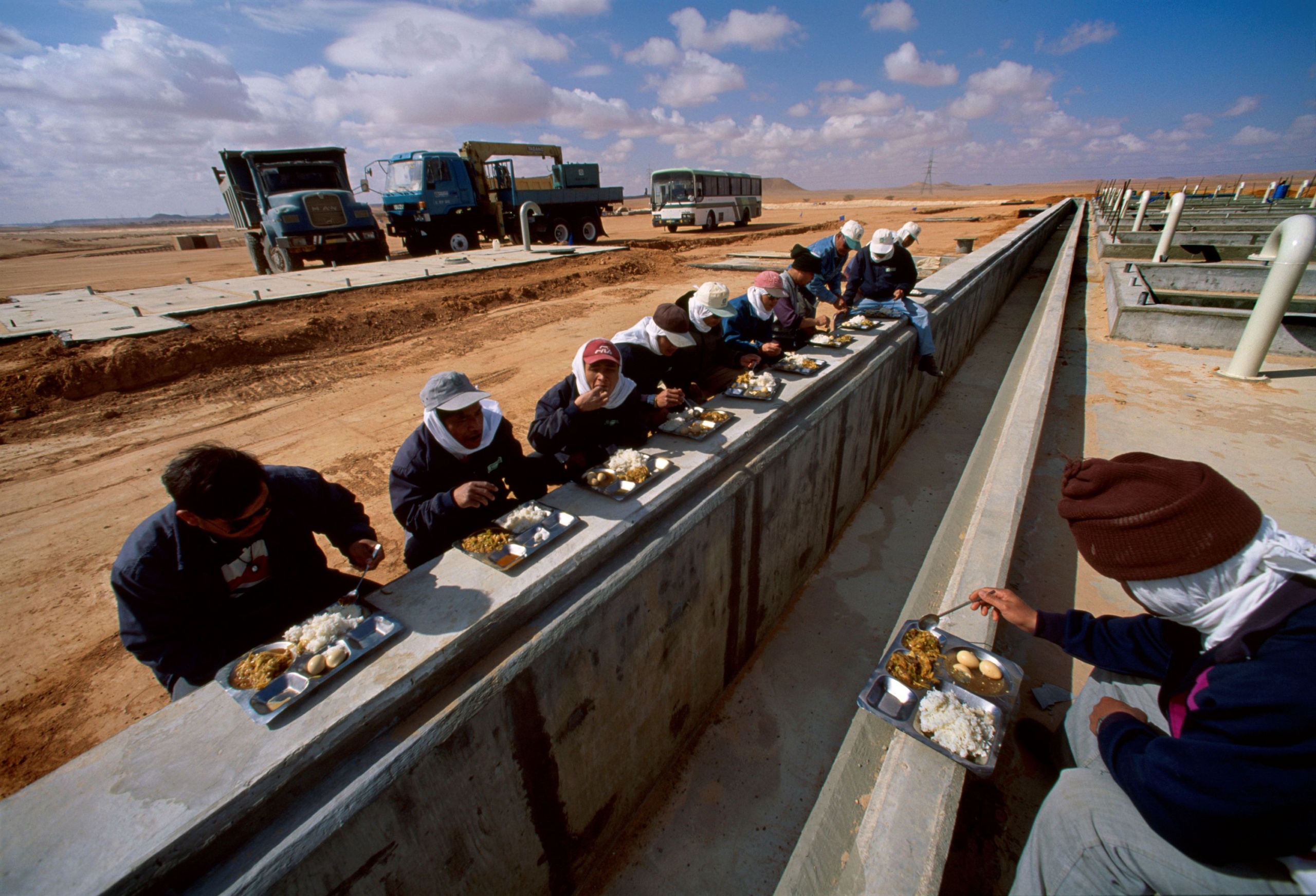Betoncső mellett ebédelő munkások.