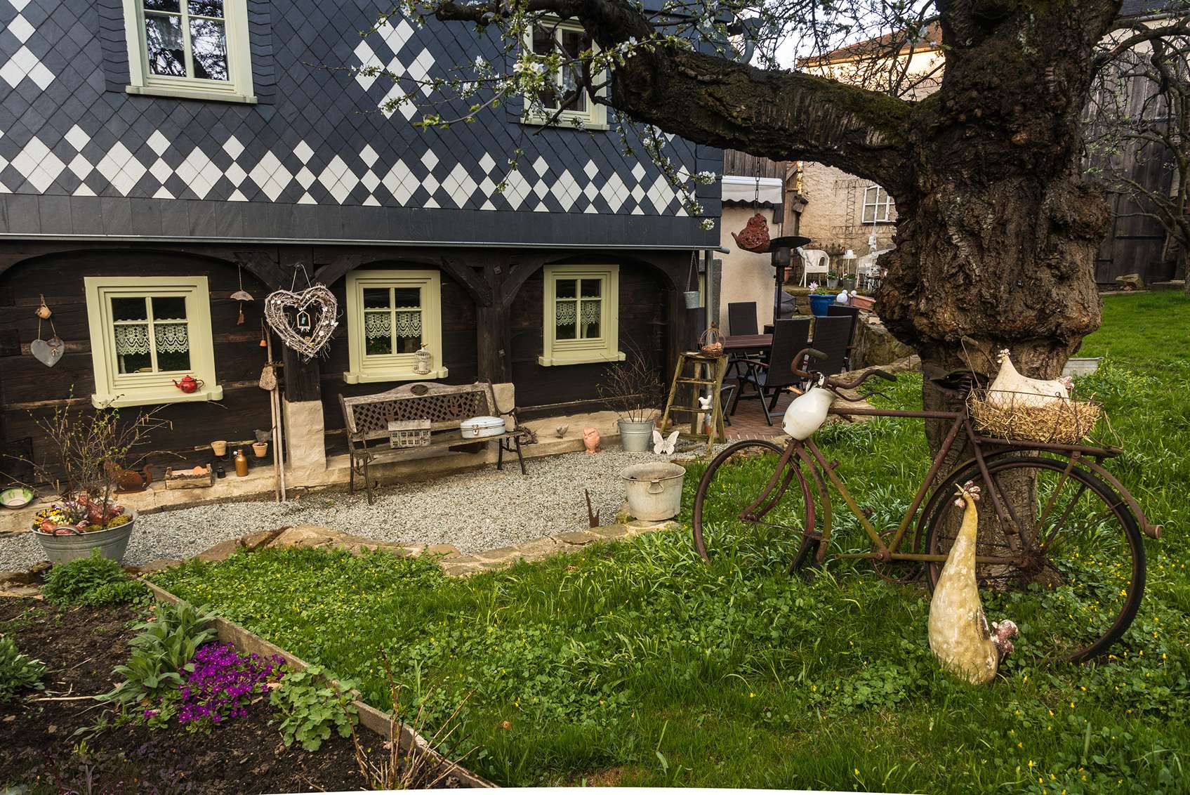 Szvíecskével és rusztikus tárgyakkal díszített vidéki udvar