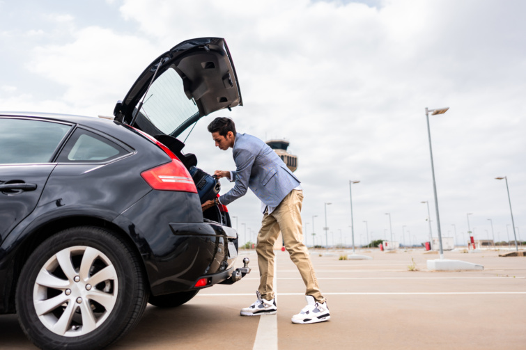 parkolas - Startlap Utazás reptéri parkolóban autóba pakoló férfi