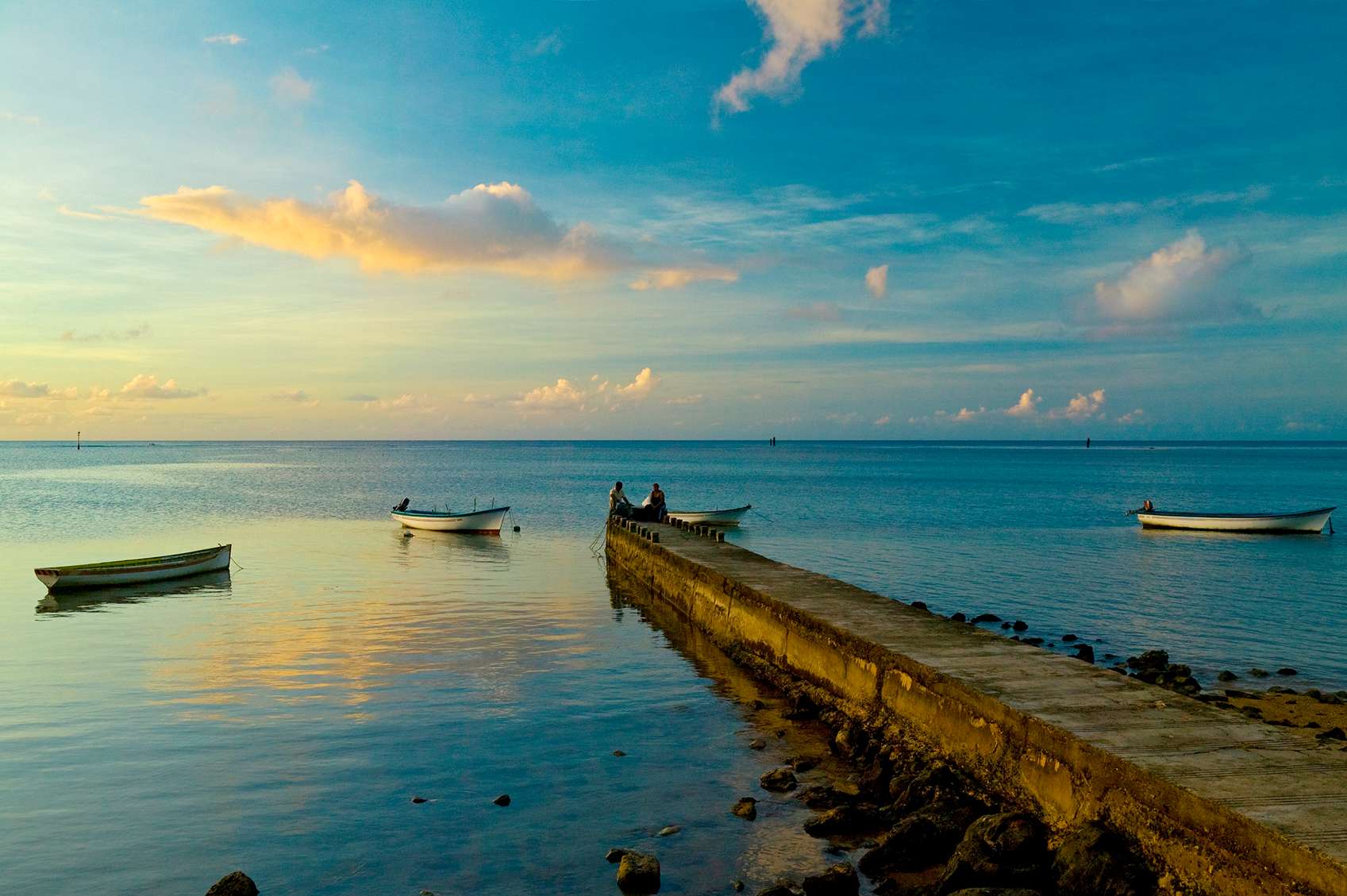 Csónak a móló végén a naplementében