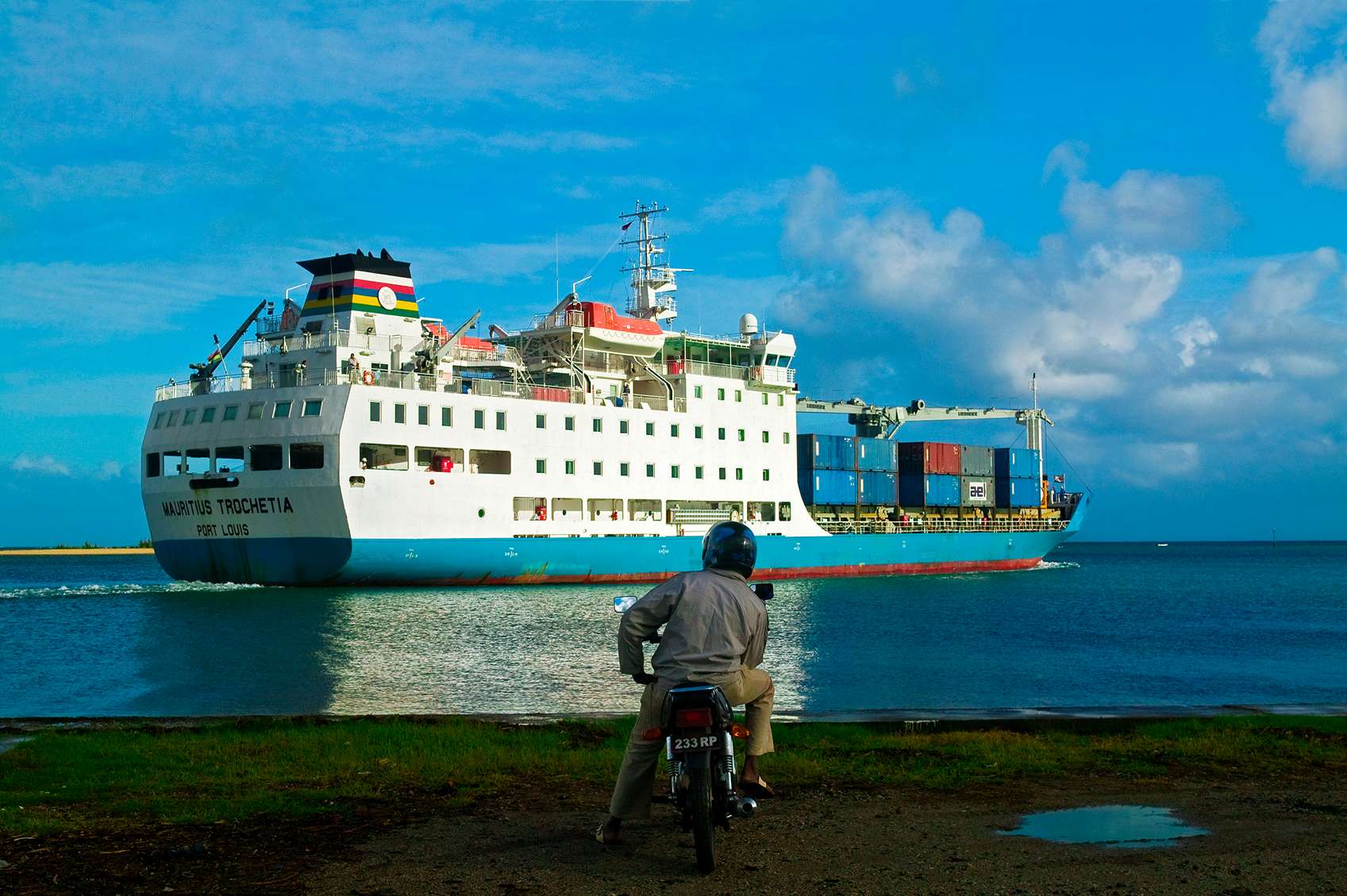 Teherhajót néző robogós férfi hátulról