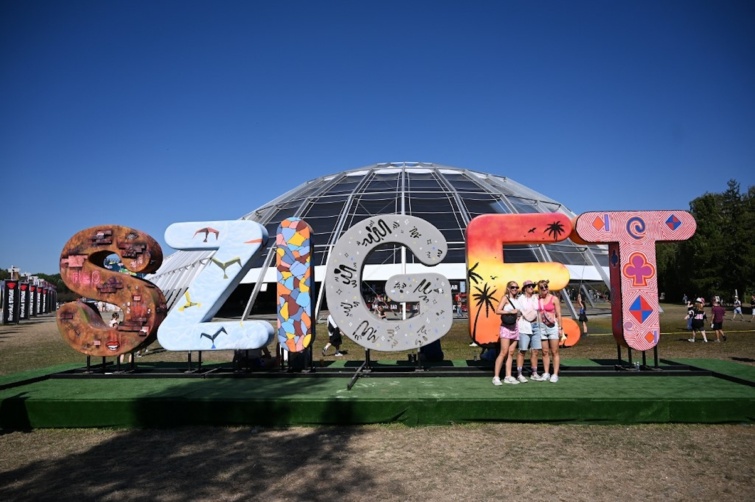 Fiatalok a Sziget fesztivál logója előtt fotózkodnak