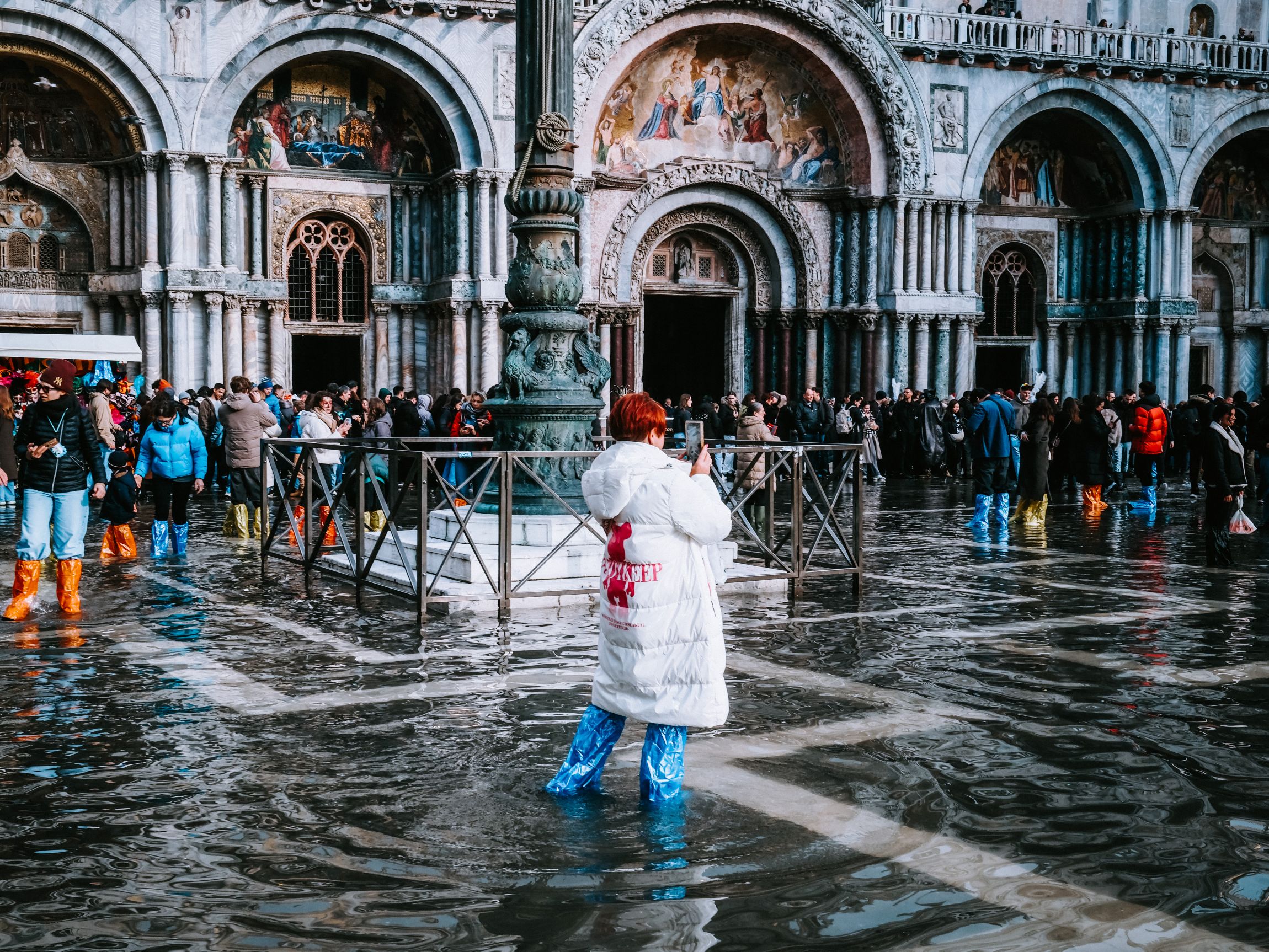 Bokáig vízben álló turista a Szent Márk téren.
