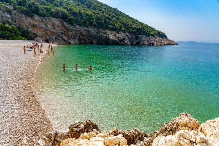 strand türkiz tengerrel fürdőzőkkel