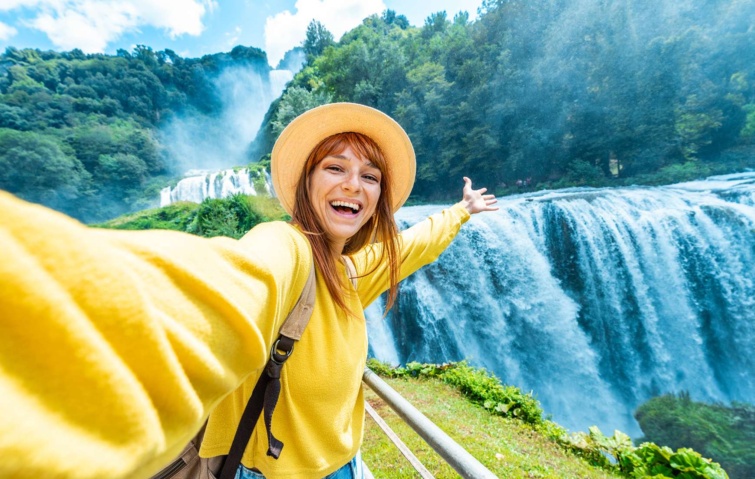 vízeséssel pózoló fiatal nő sárgában