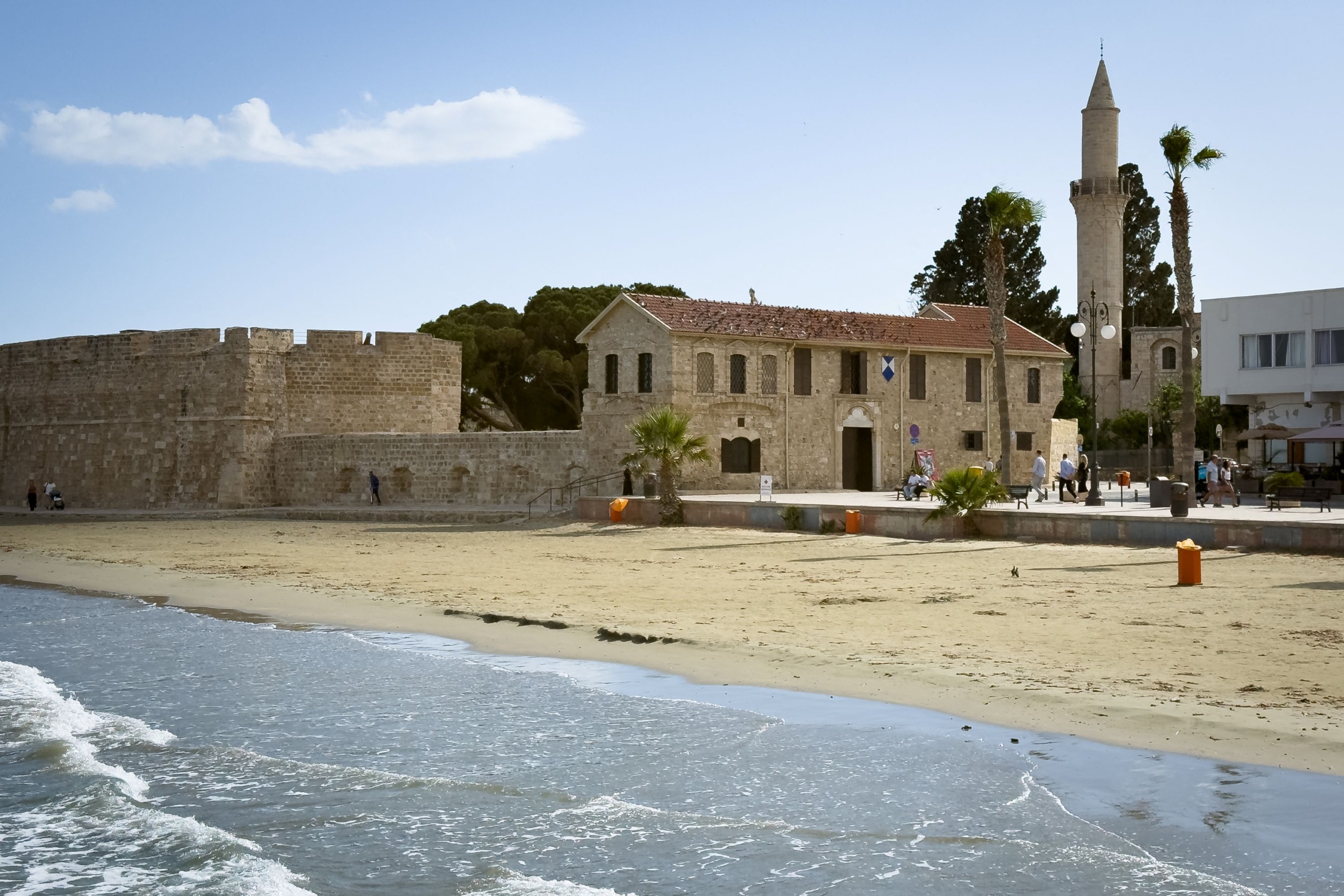Kilátás egy mólóról a Foinikoudes strandra, a lárnakai középkori várra és a Kebir-Buyuk mecset minaretjére Lárnakában