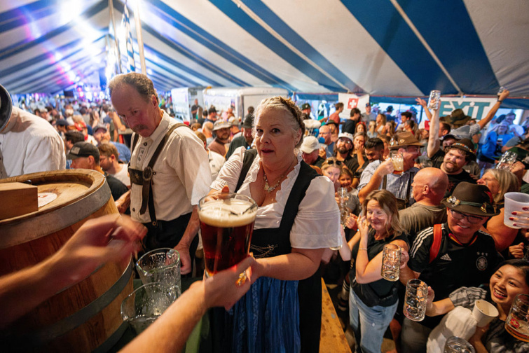 Idős nő hagyományos öltözékben kezében egy óriási korsó sörrel a 2025-ös Oktoberfesten