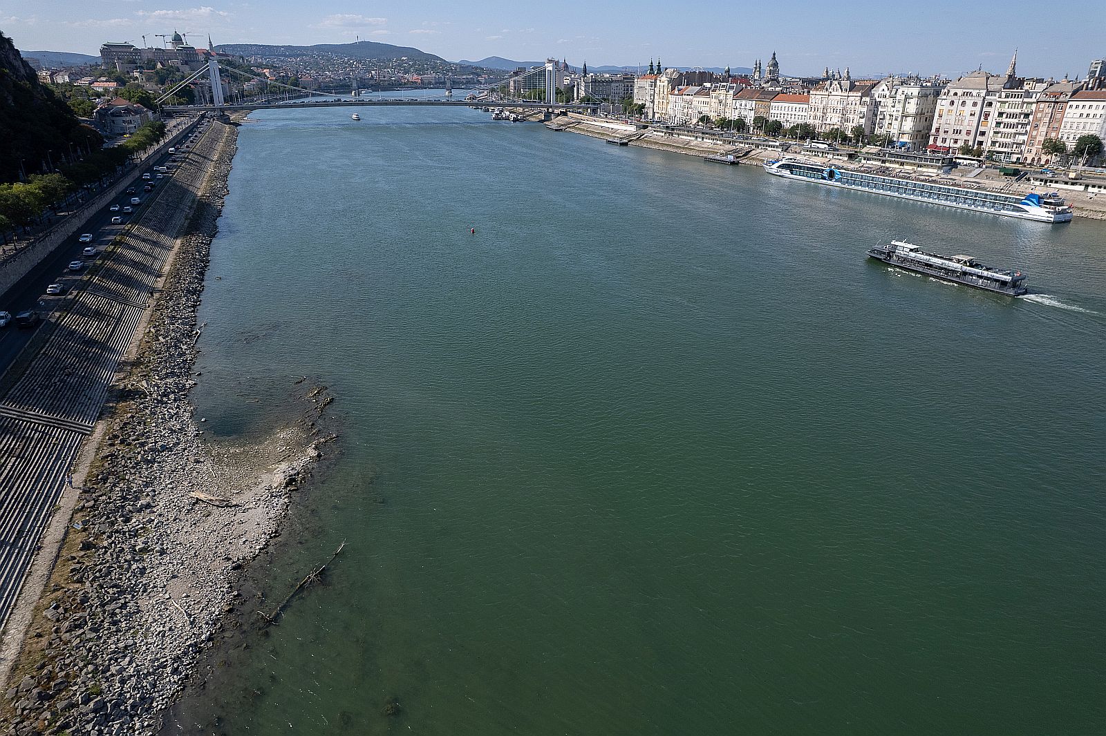 Az Ínség-szikla az apadó Dunán Budapesten, háttérben a Parlament