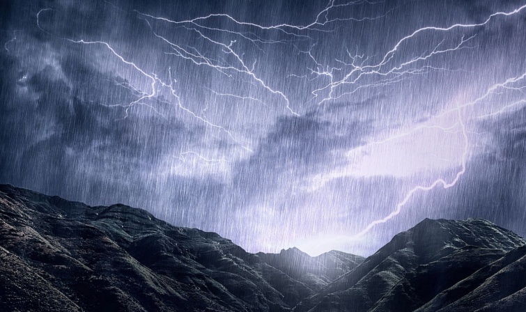 Mother Nature unleashes her rage - Startlap Utazás Villámok egy hegyvonulat felett esőben.