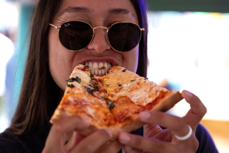 pizza zaba - Startlap Utazás Napszemüveges hölgy pizzát fogyaszt.