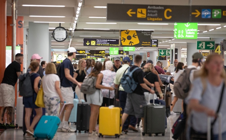 Utasok tömege bőröndökkel egy reptéren