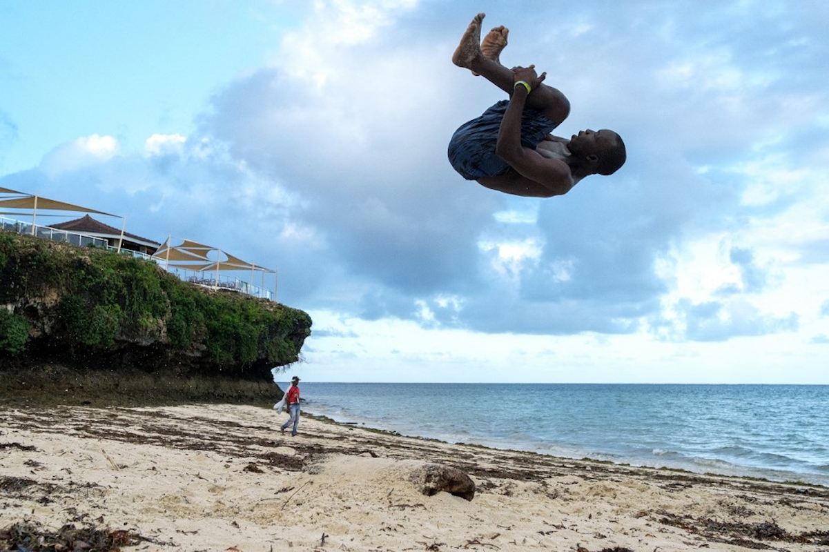 Fiatalember egy akrobatikus ugrást hajt végre a kenyai Mombasa Bamburi strandján