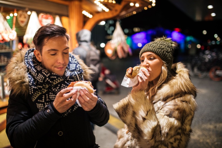 adventi-vasar - Startlap Utazás Turisták hot-dogot esznek egy adventi vásárban