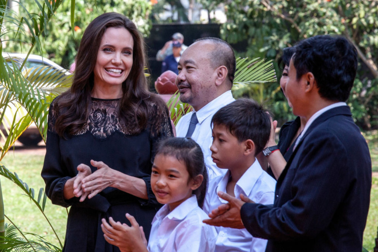 Angelina Jolie és Rithy Panh producer (középen) beszélgetnek a színészekkel, mielőtt sajtótájékoztatót tartanának új filmjük, a „First They Killed My Father” premierje előtt, amelyre 2017. február 18-án került sor a Raffles Grand Hotel D’Angkorban, Siem Reapben, Kambodzsában.