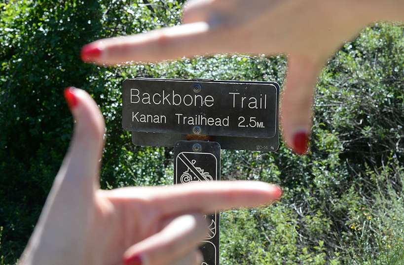 táblára mutató női kéz a BackBone ösvényen