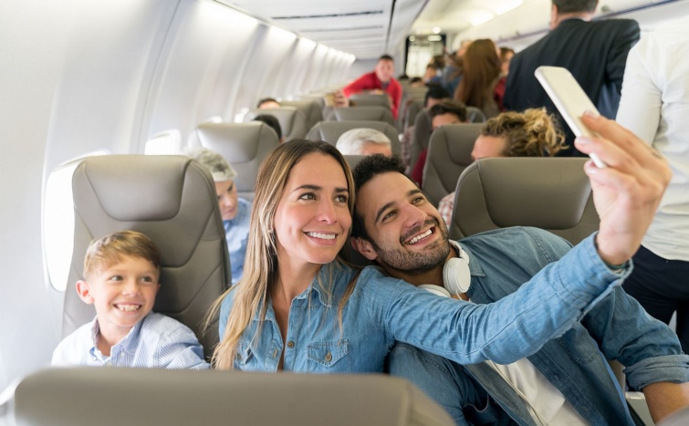 Happy family traveling by plane and taking a selfie - Startlap Utazás Egy család (apa, anya, kisfiú) vidáman szelfiznek a repülőgépen.