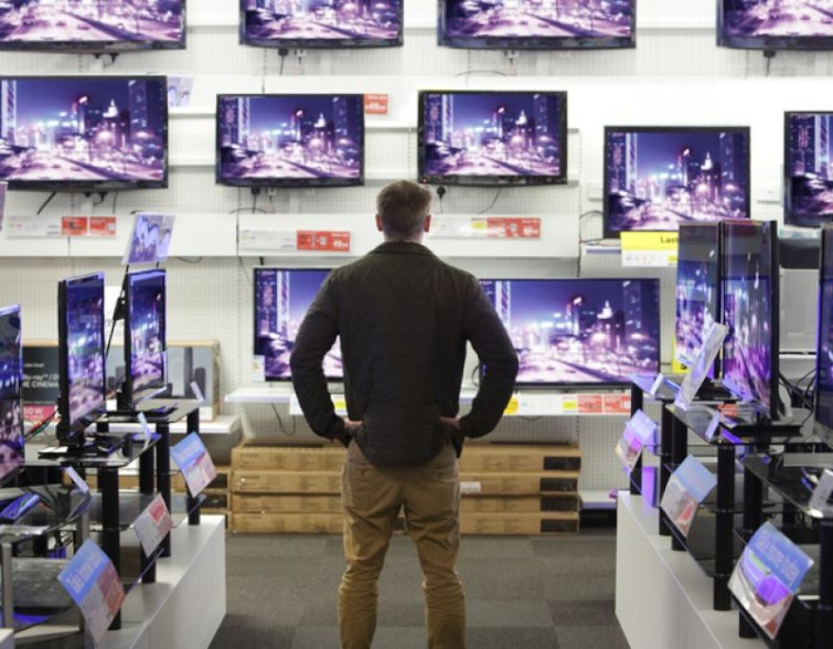 Férfi egy műszaki áruházban a tévéosztályon