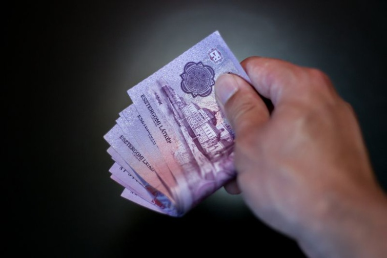Bundle of money Startlap Vásárlás Tízezer forintos bankjegyeket tart egy kéz.