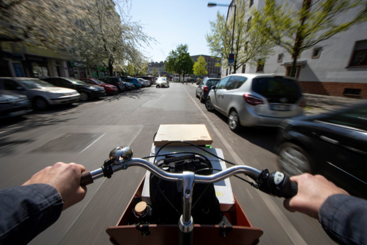 Autóút elsuhanó látképe egy rakományt szállító biciklis szemszögéből.