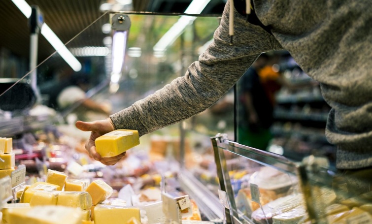 Valaki sajtot vásárol az egyik élelmiszerüzletben